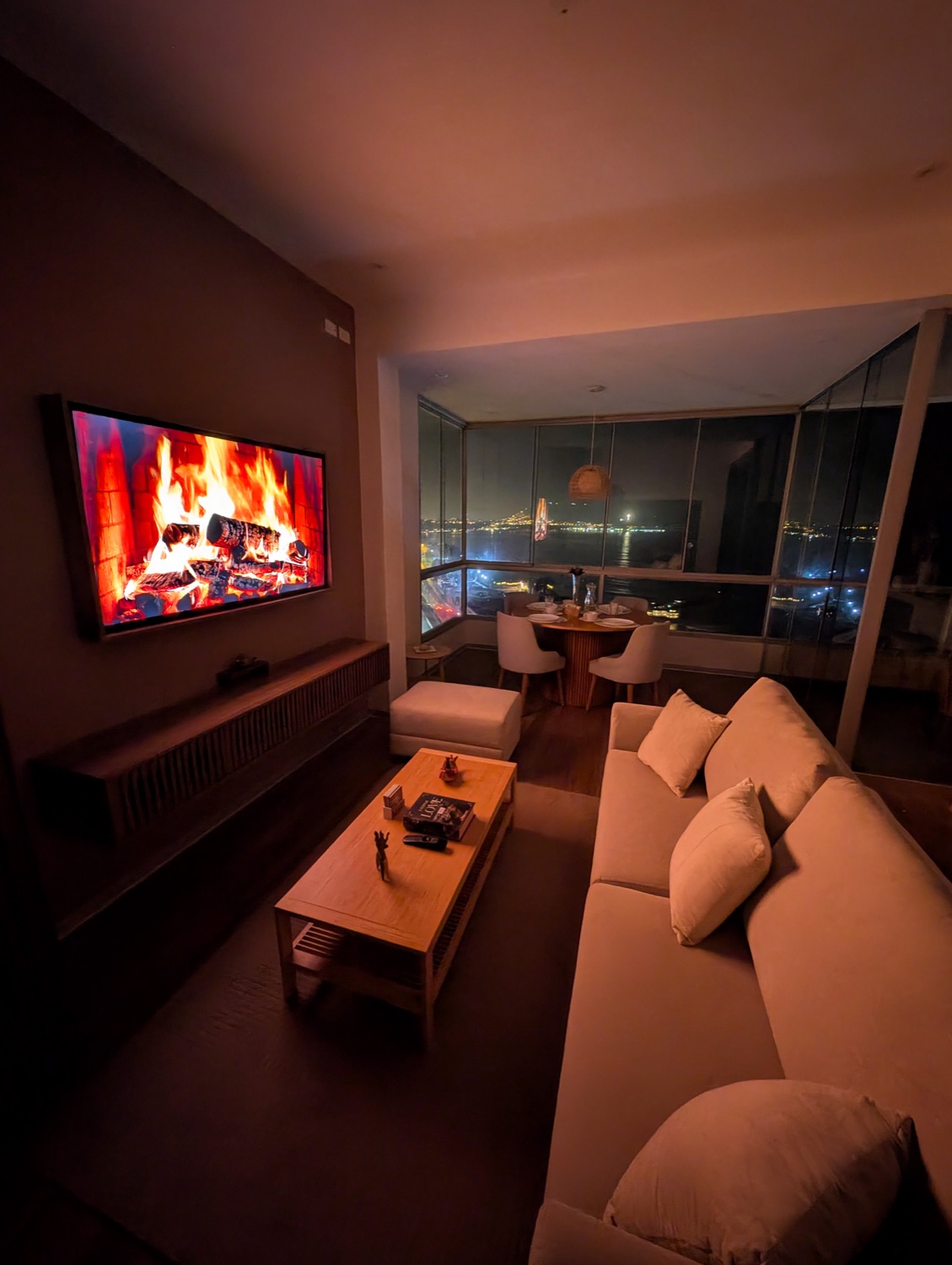 Living room at night with the city lights along the coast