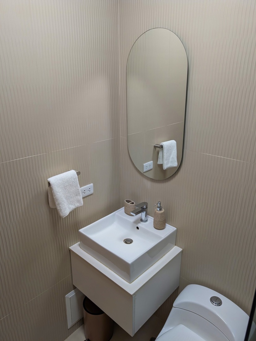 Bathroom with oval mirror and stone tile